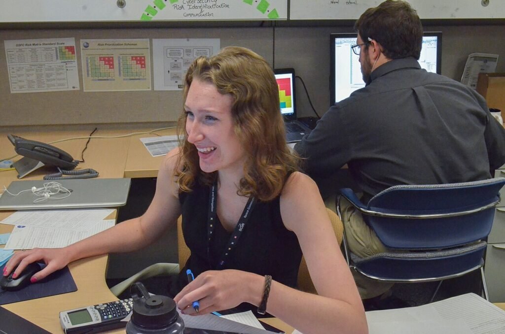 A cybersecurity professional working at computer screens in an office